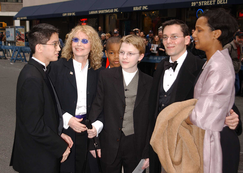 Mia Farrow (2nd-L) and her adopted children all dressed up in black suits for a wedding