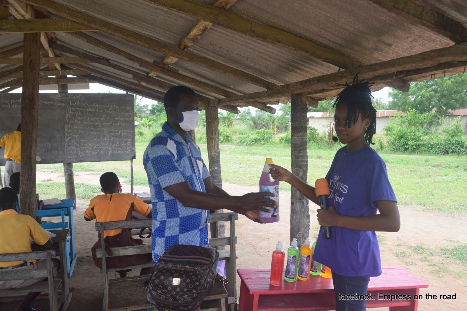 Photo of Empress Esi gifting liquid soaps to a school in Ghana.