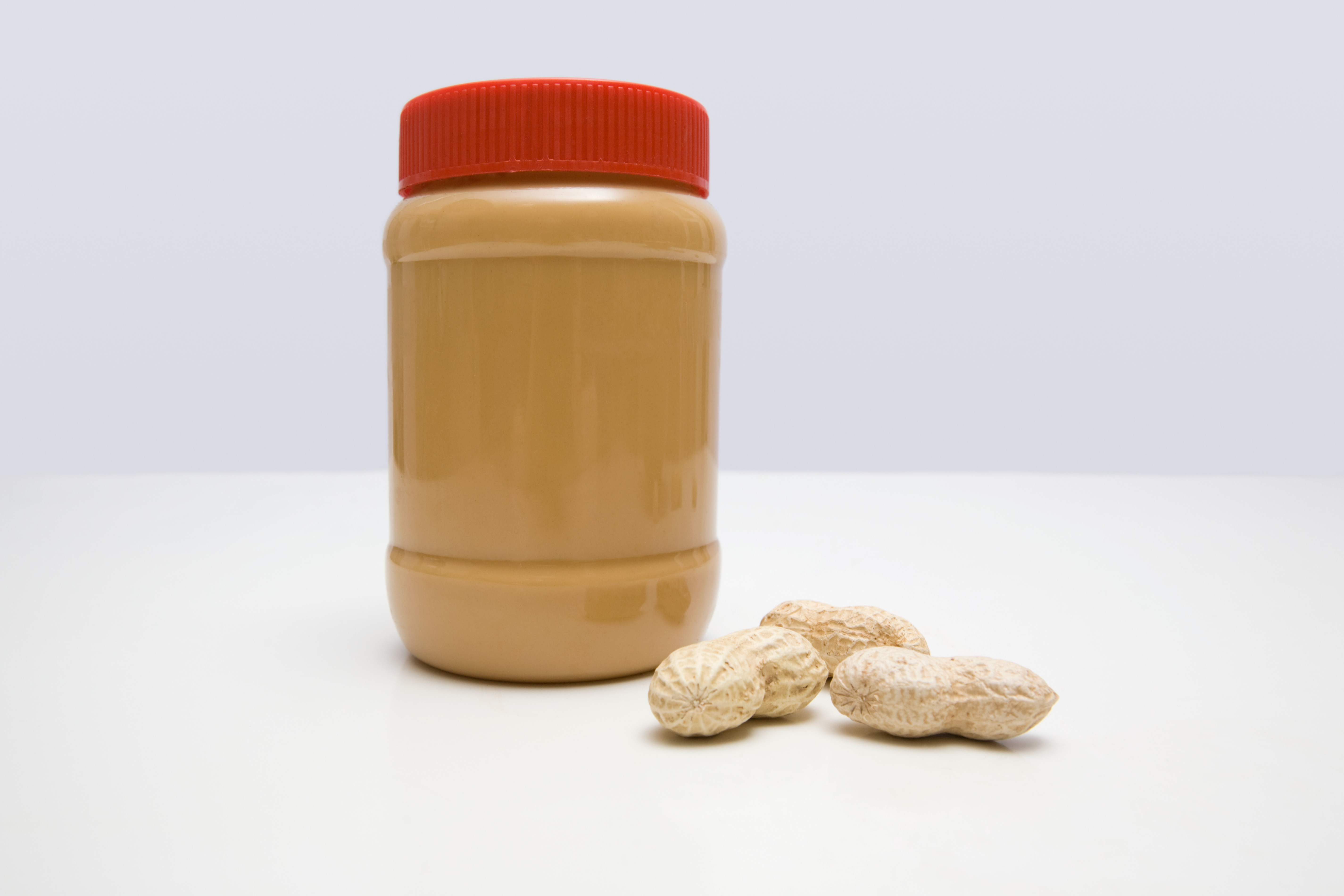 A jar of peanut butter and peanuts