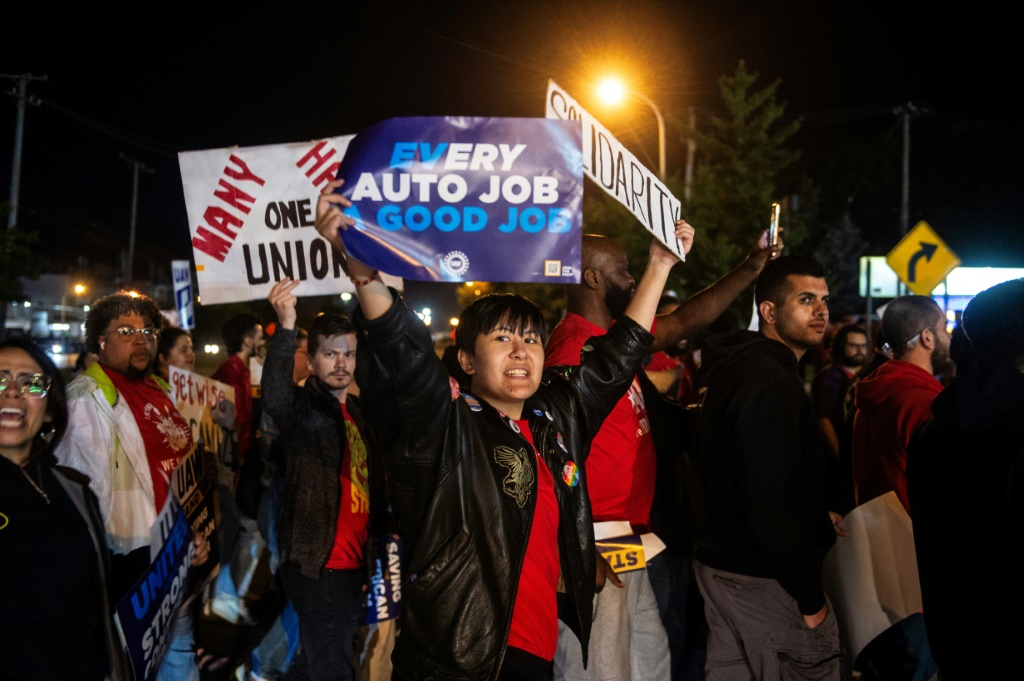 Members of the UAW (United Auto Workers) picket and hold signs outside of the UAW Local 900 headquarters across the street from the Ford Assembly Plant in Wayne, Michigan on September 15, 2023