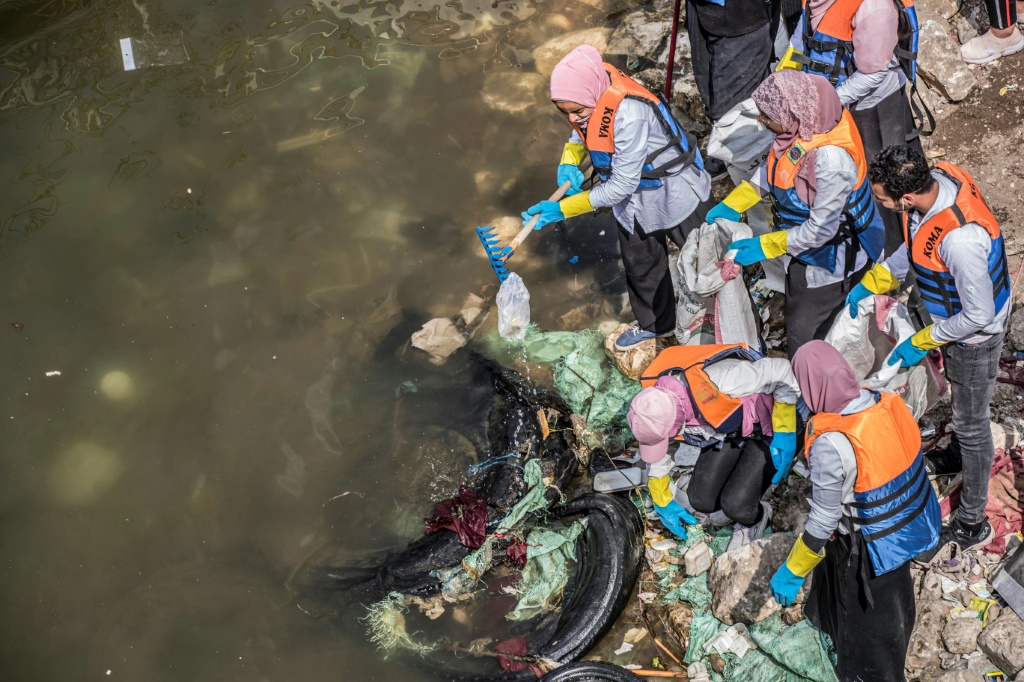 Volunteers collect garbage from the Nile in Egypt's capital Cairo in a clean-up campaign, on March 7, 2020