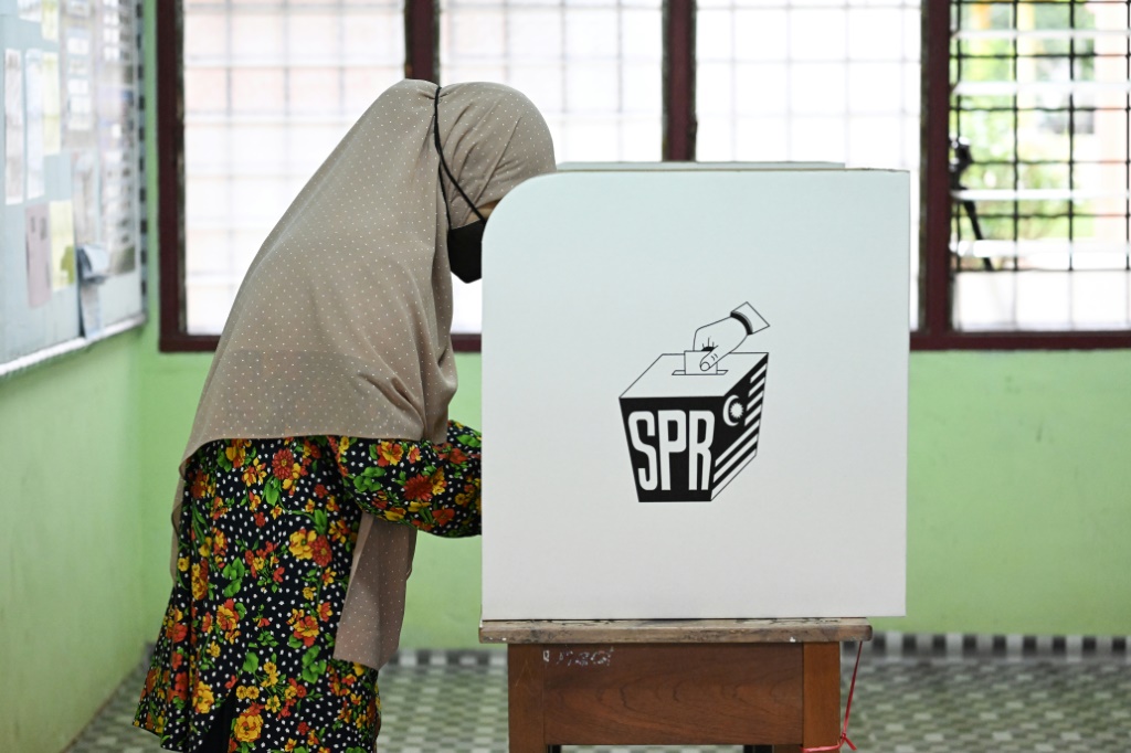 A woman casts her vote at a polling station during Malaysia's 15th general election