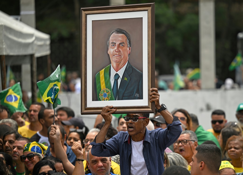 A supporter holds up a portrait of Brazil's far-right President Jair Bolsonaro at a rally