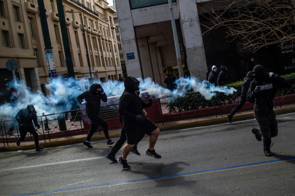 Protesters flee tear gas fired by Greek riot police in Athens