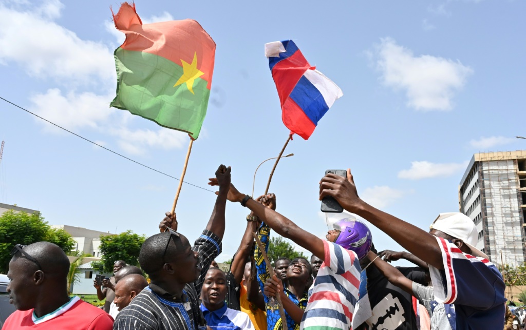 A small group of protesters wave Russian and Burkina Faso flags in Ouagadougou after a new coup