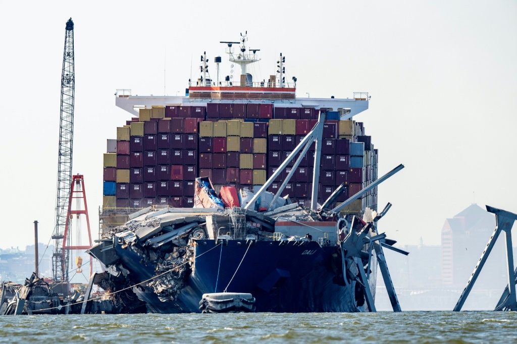 A section of the Francis Scott Key Bridge rests in the water next to the Dali container ship in Baltimore on May 13, 2024, after crews conducted a controlled demolition