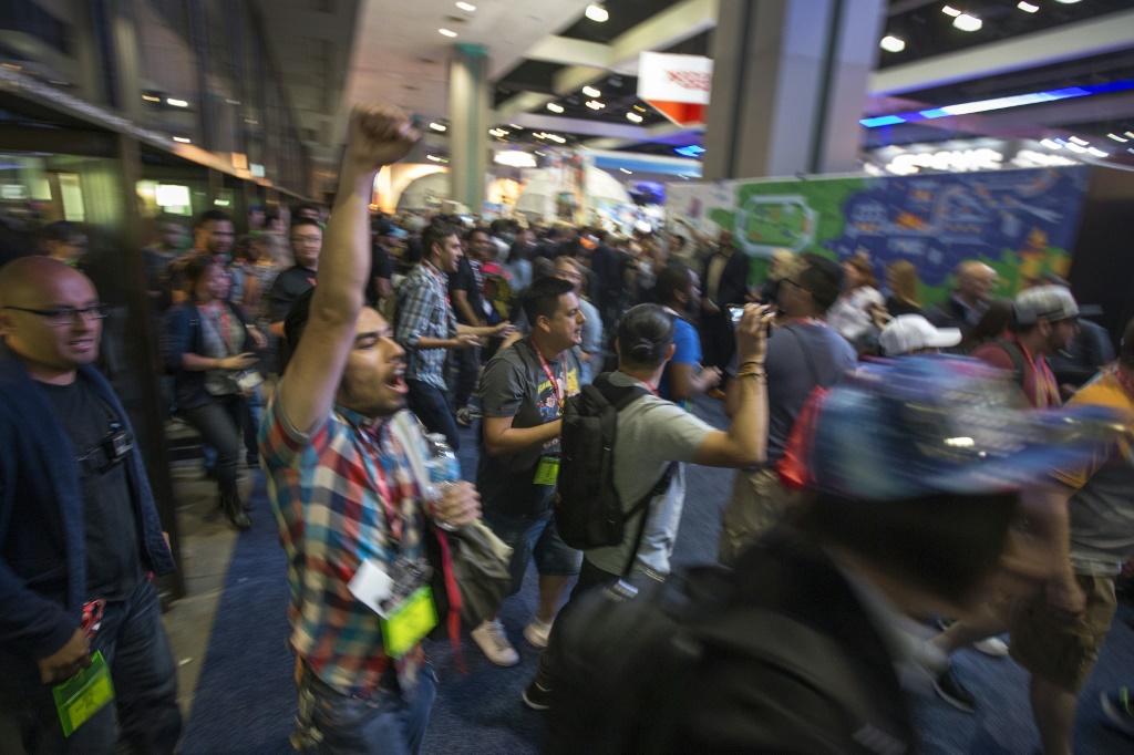 People rush into an exhibit hall on opening day of the Electronic Entertainment Expo (E3) at the Los Angeles Convention Center in June 2017