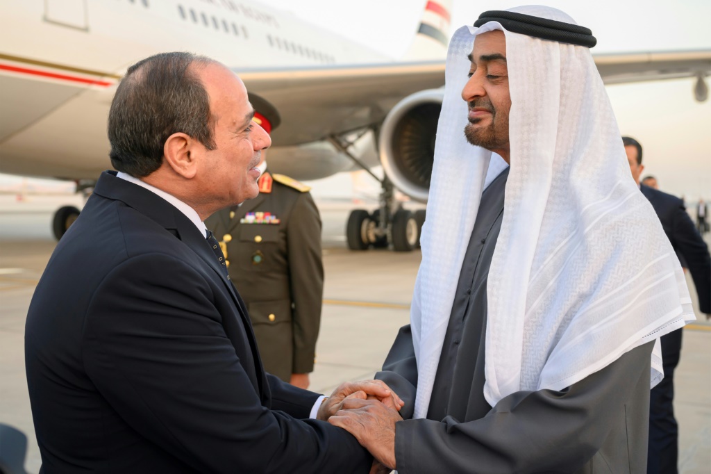 A handout picture released by the United Arab Emirates' presidential court shows Emirati President Sheikh Mohamed bin Zayed Al-Nahyan (R) welcoming Egypt's President Abdel Fattah al-Sisi in Abu Dhabi on February 12, 2023