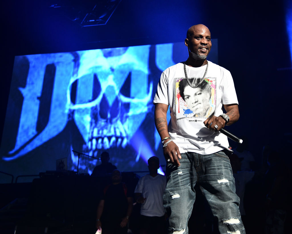 DMX performs in a white tee, denim jeans, and silver jewerellery.