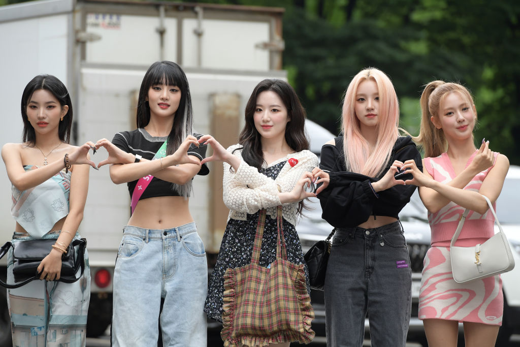 GI-DLE, one of the most popular K-pop groups internationally, pose for a photo, making love heart patterns.