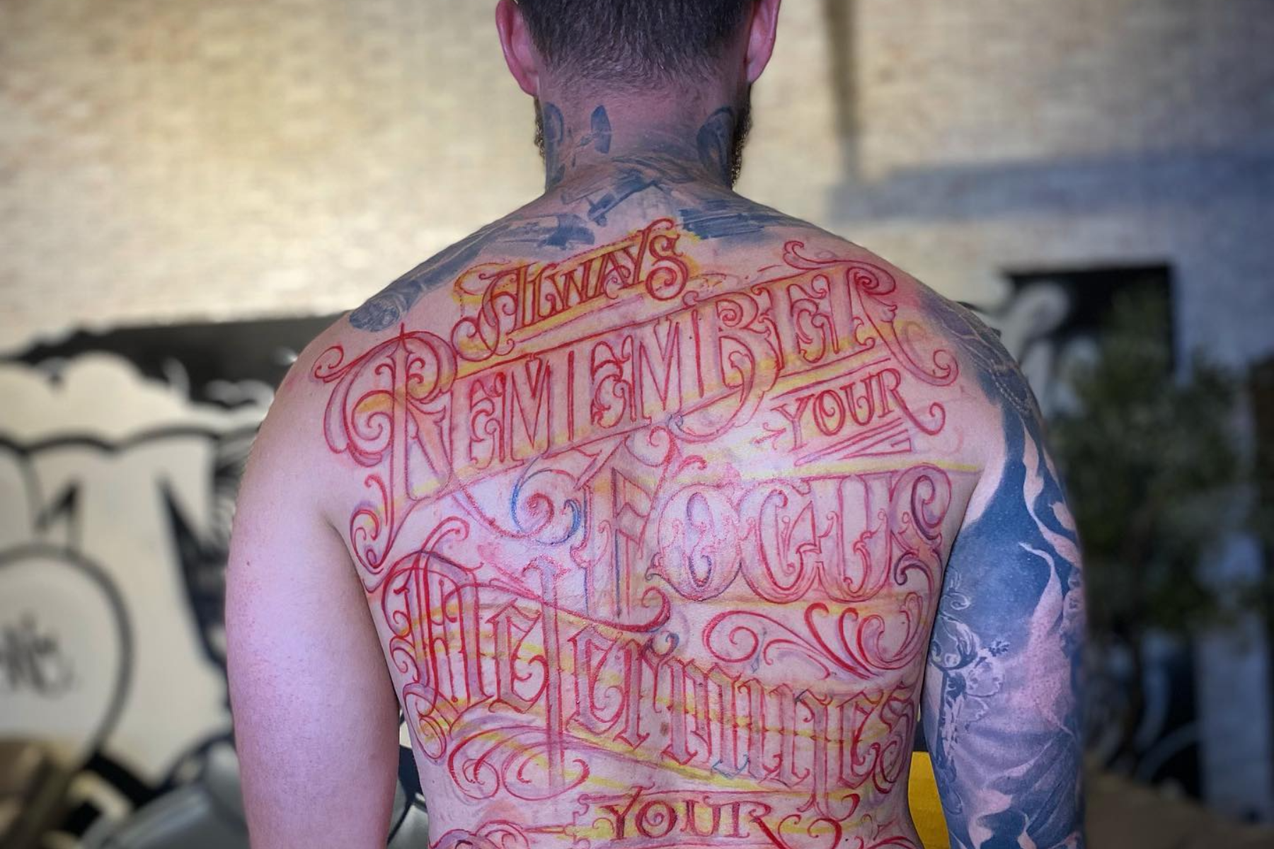 A man with a full back text tattoo