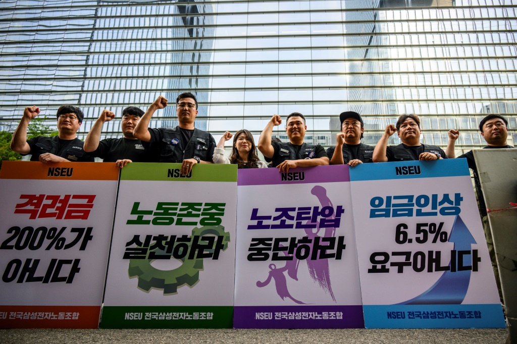 Samsung Electronics' union members hold placards during a rally outside the company building in Seoul