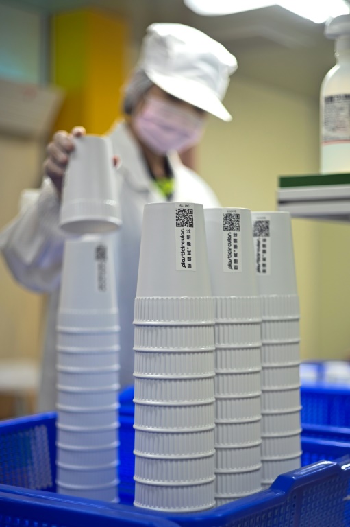 A staff member from Taiwan's Blue Ocean, an environmental protection company, examines a reusable mug