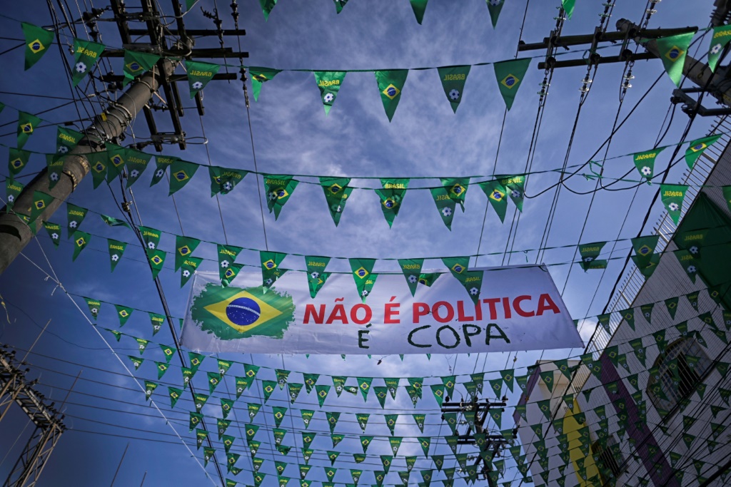 With Brazil's incumbent President Jair Bolsonaro adopting the colors of the flag as his own, Julio Cesar Freitas felt compelled to add a clarification to his family's green and yellow street decorations: 'It's not politics, it's the World Cup'