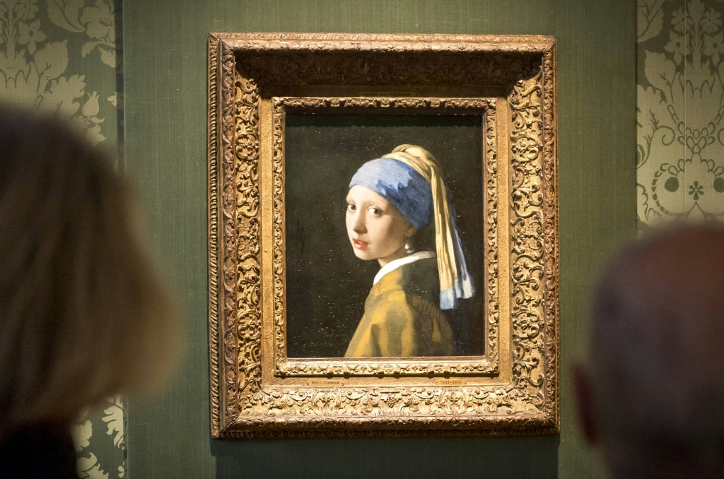 Two activists glued themselves to Johannes Vermeer's 'Girl with a Pearl Earring' and the adjoining wall, but the artwork was behind glass and undamaged