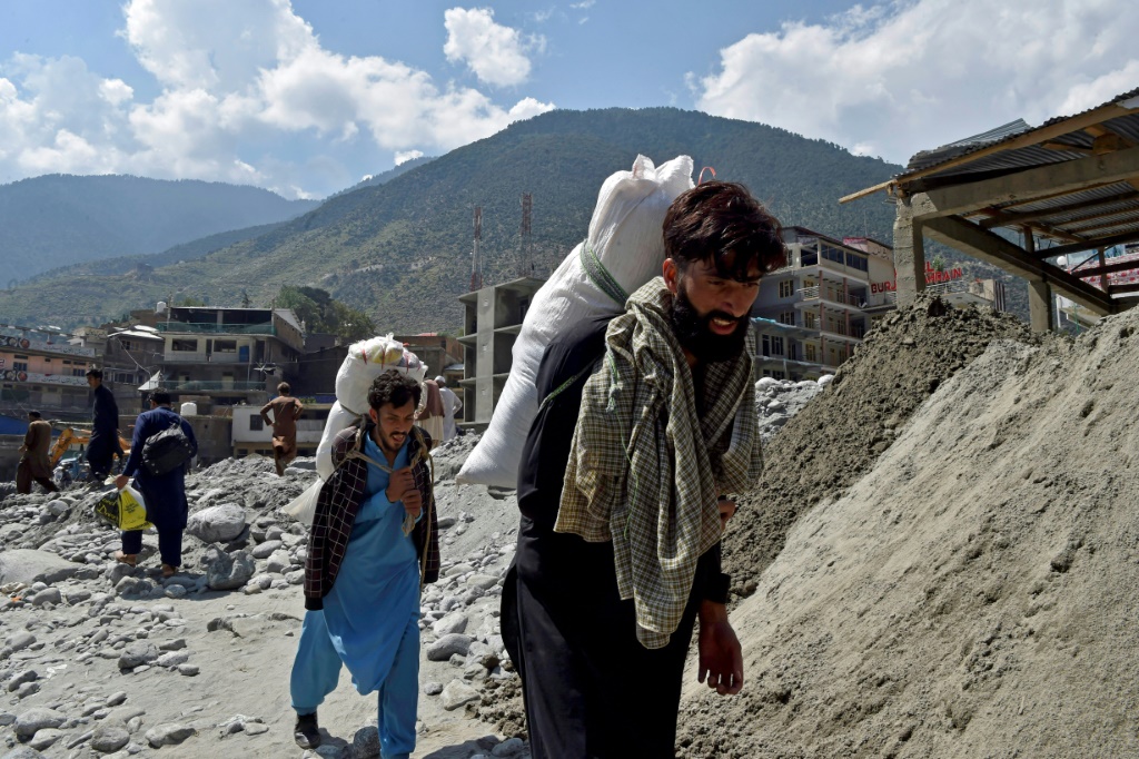 Locals have to carry supplies to remote villagers by foot after roads and bridges were destroyed