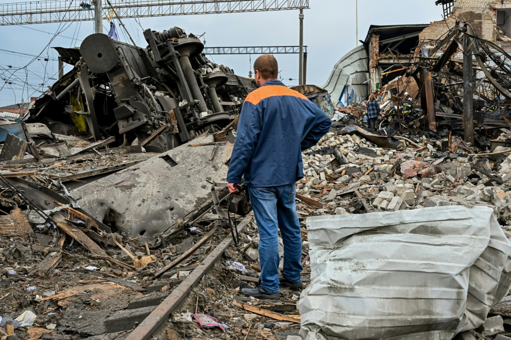 A worker inspects the damage near a railway yard of the freight railway station in Kharkiv, which was partially destroyed by a missile strike
