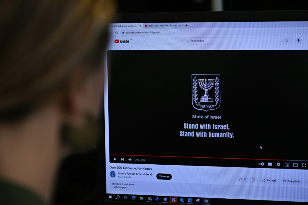 This photograph taken on October 26, 2023, shows a woman looking at a computer screen in Paris, displaying an advertisement on the YouTube platform for a campaign financed by The Israeli Ministry of Foreign Affairs.
 Thousands of civilians, both Palestinians and Israelis, have died since October 7, 2023, after Palestinian Hamas militants based in the Gaza Strip entered southern Israel in an unprecedented attack triggering a war declared by Israel on Hamas with retaliatory bombings on Gaza.