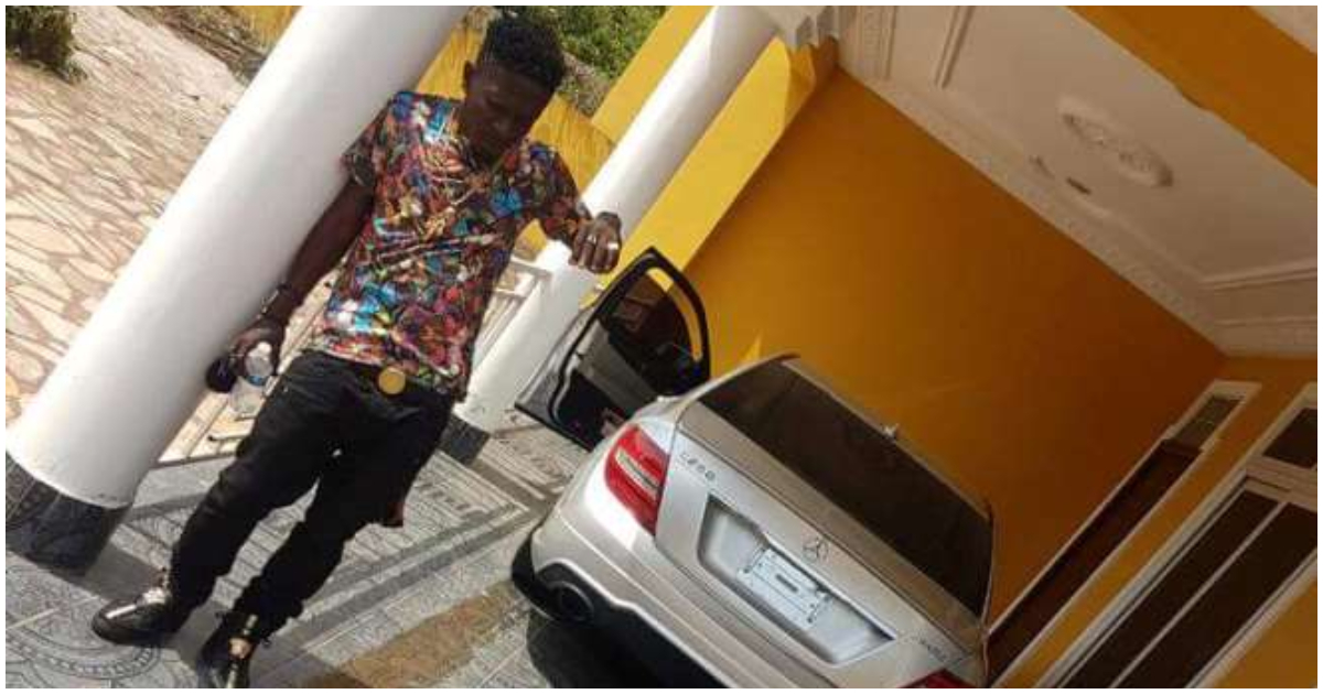 Shatta Wale poses in front of the house