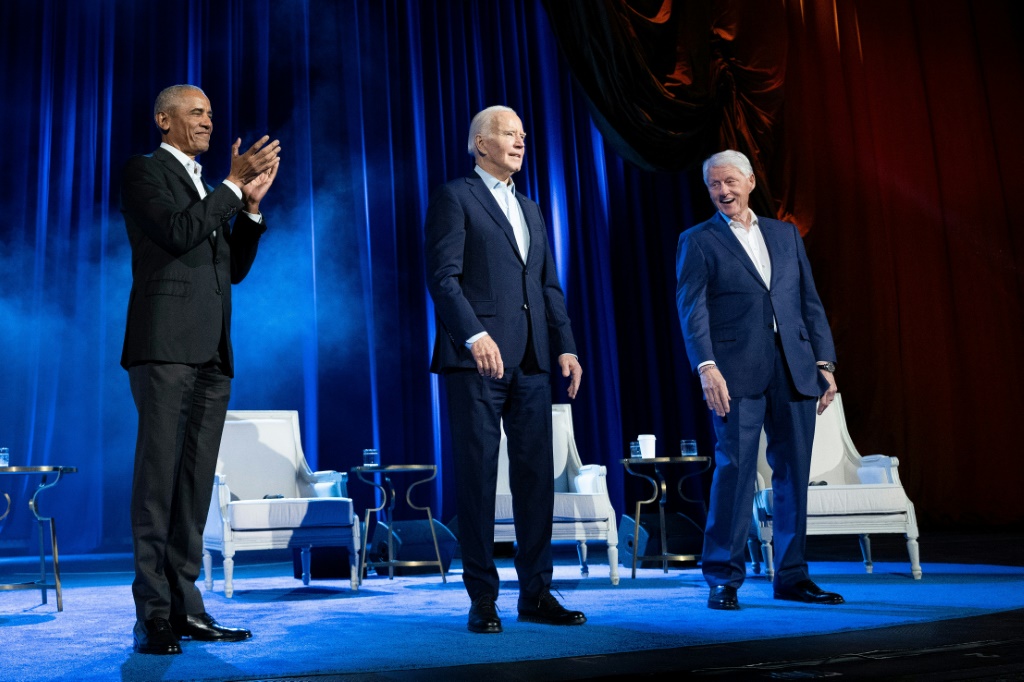 Former US President Barack Obama (L) and former US President Bill Clinton (R) cheer for US President Joe Biden during a campaign fundraising event at Radio City Music Hall in New York City in March