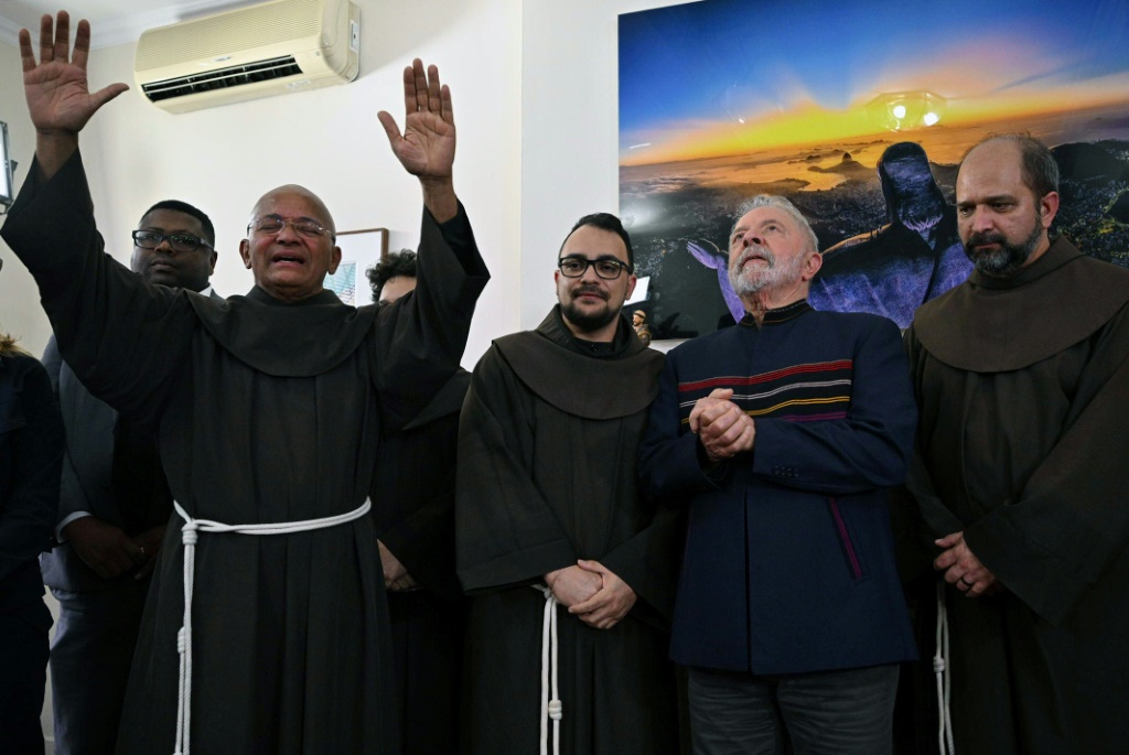 Fray Davi gives his blessing next to (L to R) Fray Gabriel, Brazilian former President (2003-2010) and candidate for the leftist Workers Party (PT) Luiz Inacio Lula da Silva, and Fray Paulo during a meeting to commemorate St. Francis of Assisi day, at the campaign headquarters in Sao Paulo, on October 4, 2022.
