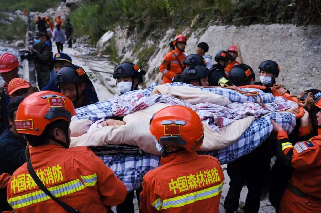 Rescue workers carry an injured person after a 6.6-magnitude earthquake struck China's southwestern Sichuan province on Monday