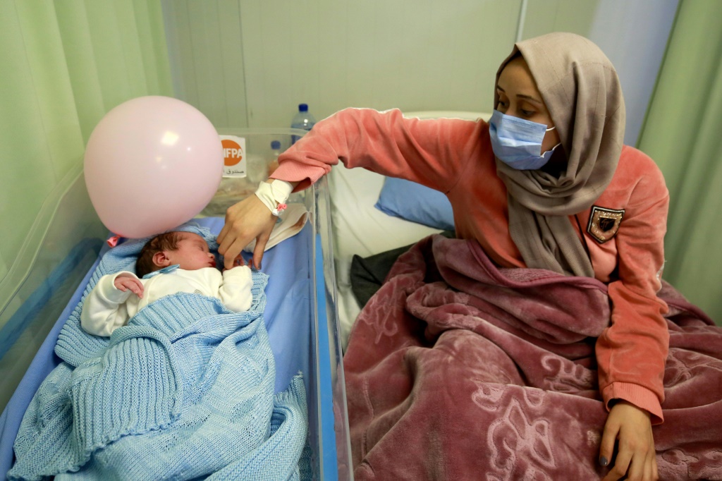 Syrian refugee Nagham Shagran, 20, watches over her newborn baby Zaid. At least 168,500 Syrian babies have been born in Jordan since 2014, according to the UN