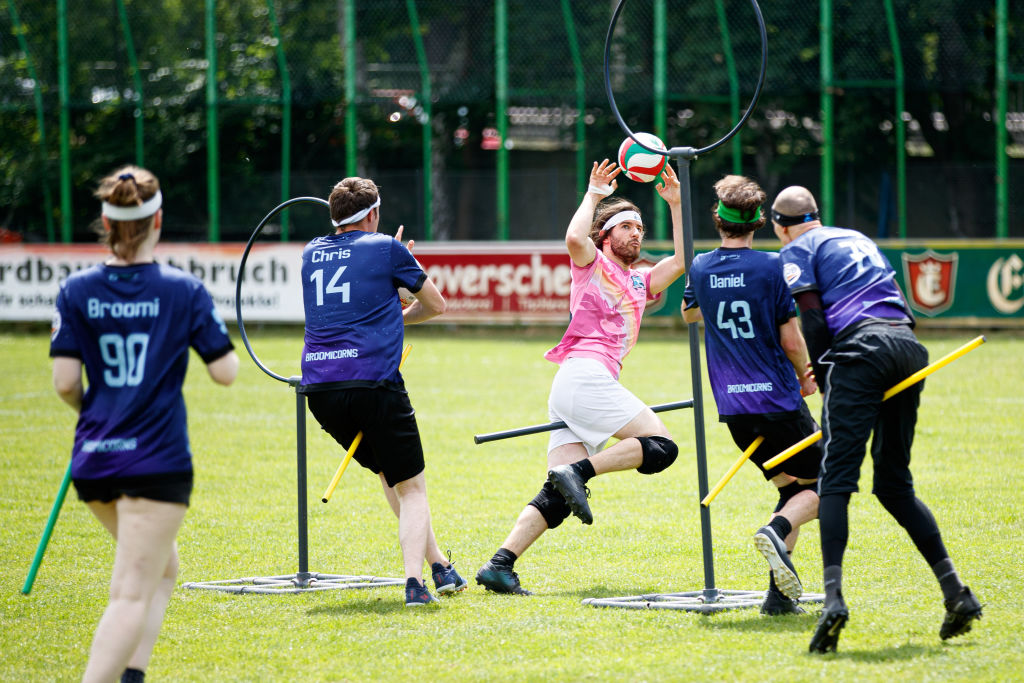 Robin Menzel throws the Quaffle through a ring to score a goal against the "Bröwicorns"
