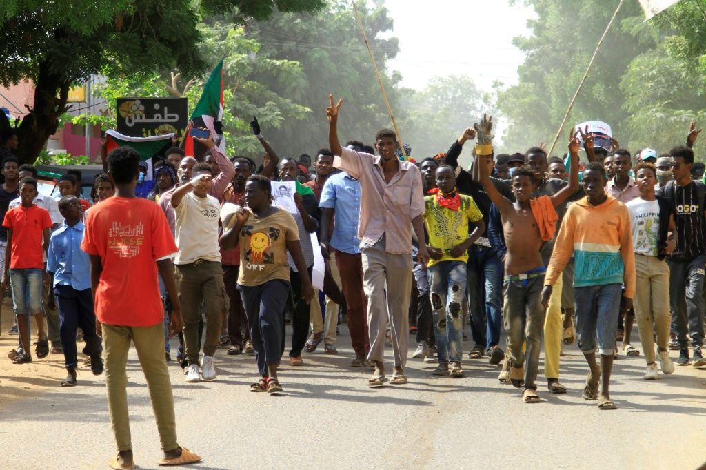 Sudanese anti-coup demonstrators march in  the capital's twin city of Omdurman