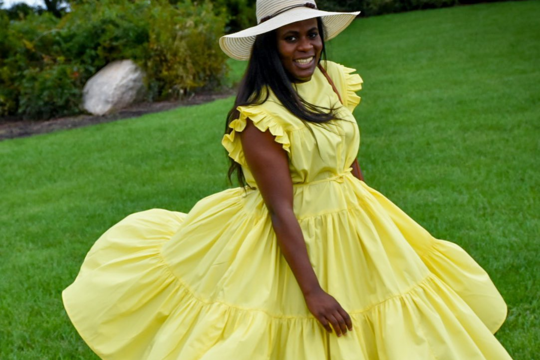 A woman is wearing a yellow skater dress