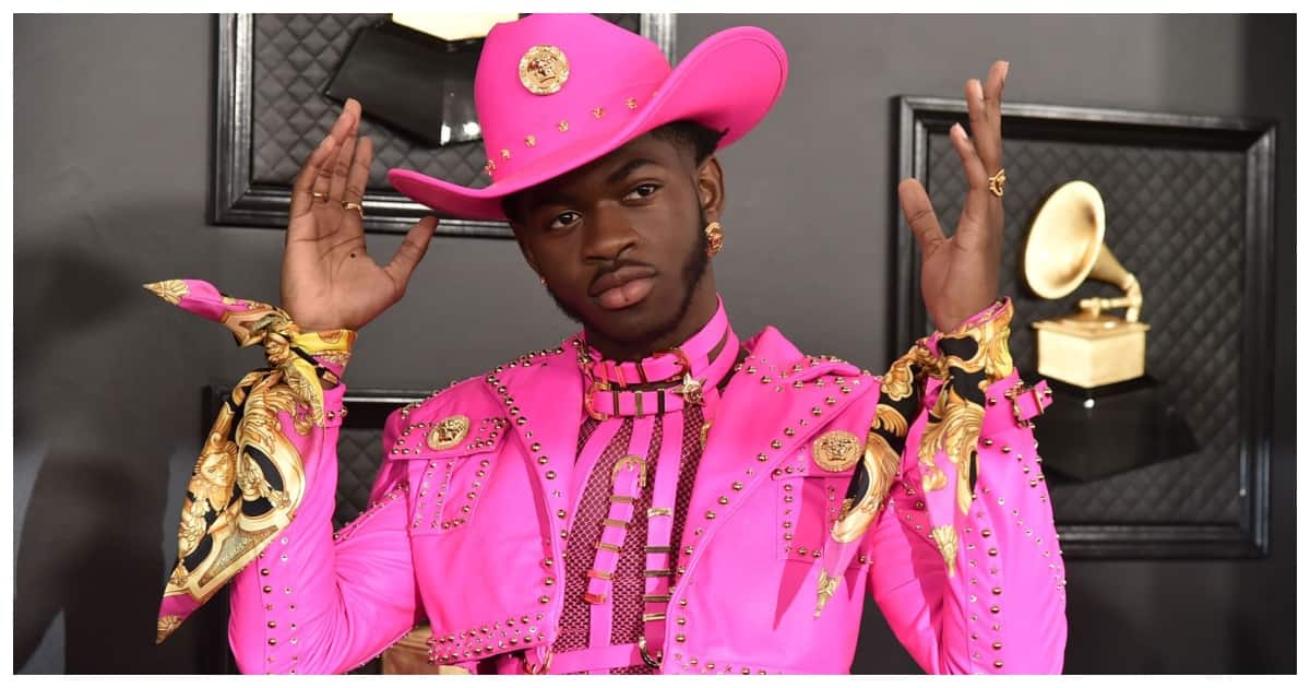 Lil Nas shows up in a unique purple outfit at VMAs red carpet event.