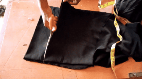 A tailor cutting out a waistband