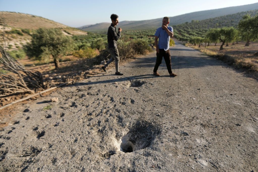 People inspect the site where a US drone targeted killed Maher al-Agal, a leader in the Islamic State militant group near Jindires in northern Syria.