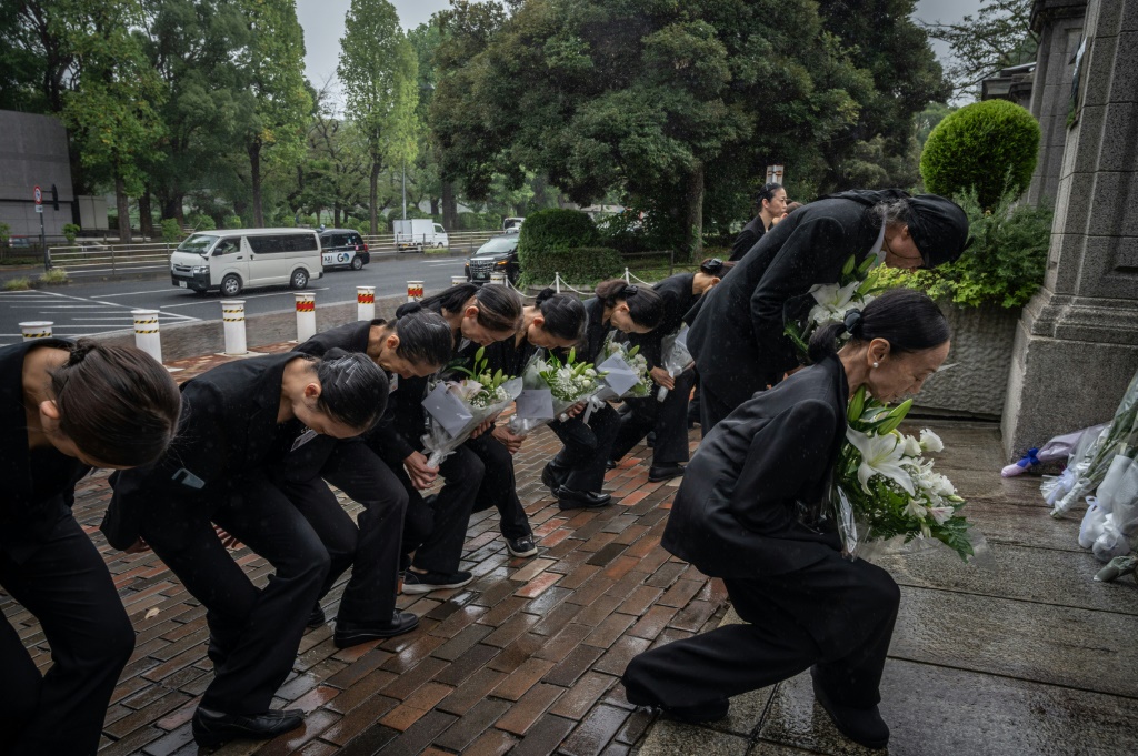 Members of a ballet company lay flowers outside the British embassy in Tokyo