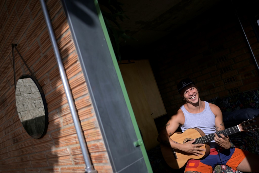 Brazilian artist Kdu dos Santos plays the guitar in his home in Belo Horizonte; the small house was recently declared "house of the year" by a specialized architecture website