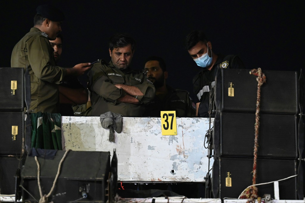 Investigators examine the rooftop of the container truck where Imran Khan was shot