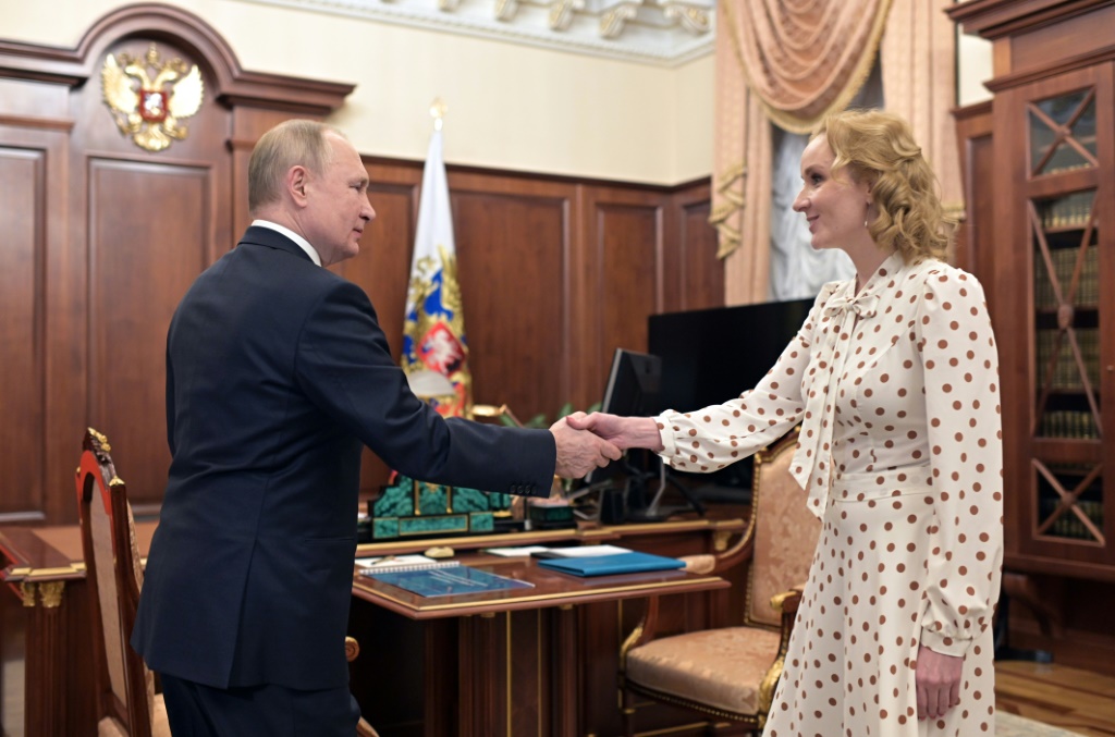 Russian Children's Rights Commissioner Maria Lvova-Belova (R, with Russian President Vladirmir Putin) was accused by the US of directing an operation to remove children from Ukraine to place with Russian families.