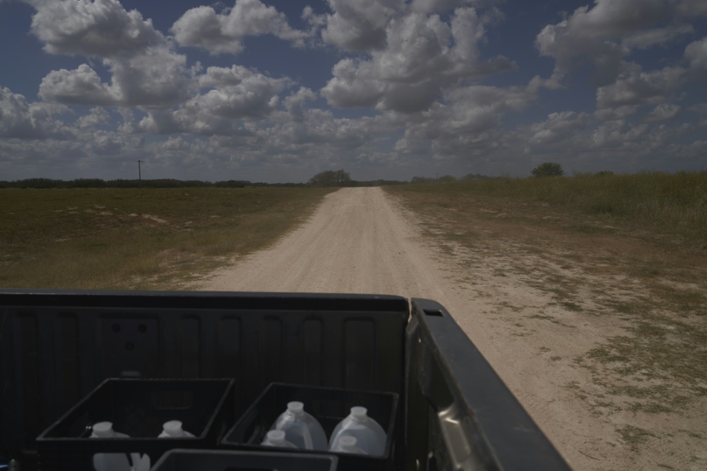 The South Texas Human Rights Center supplies blue plastic barrels of water that have location coordinates and a phone number to call for help