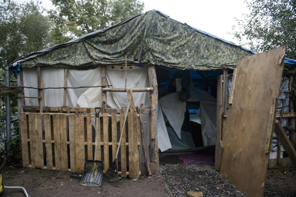 A housing structure, including a tent, is seen in a makeshift homeless encampment in a park in Granby, Canada