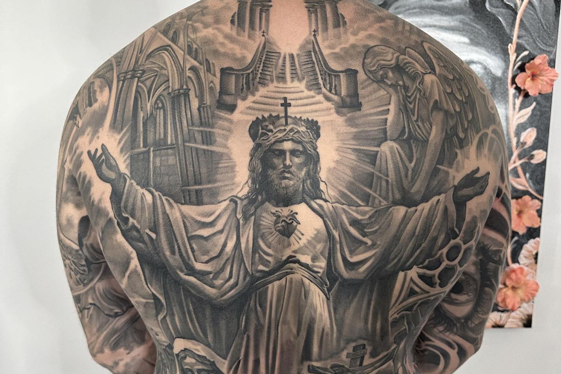 A man wearing a full-back religious tattoo