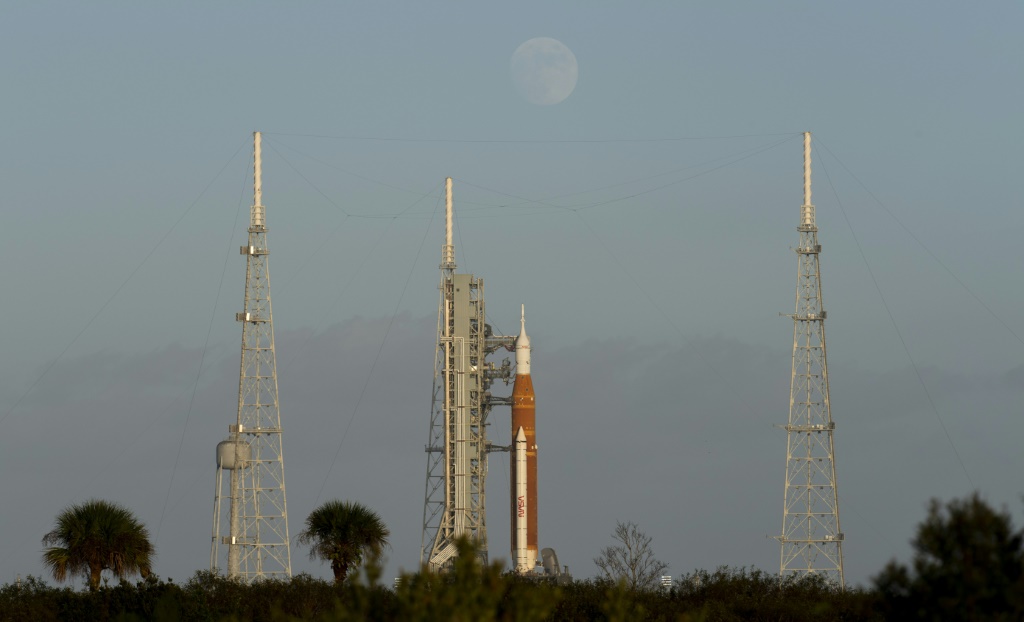 This NASA handout photo shows the Moon as it rises behind NASA's Space Launch System (SLS) rocket