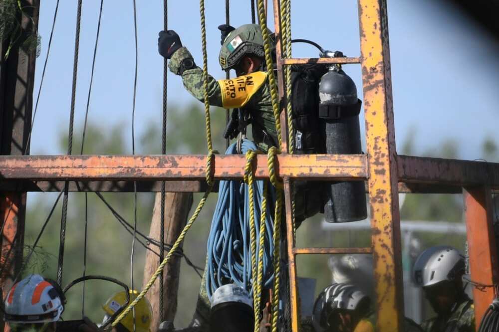 A soldier is lowered into a flooded mine in Mexico in a bid to reach 10 miners trapped inside