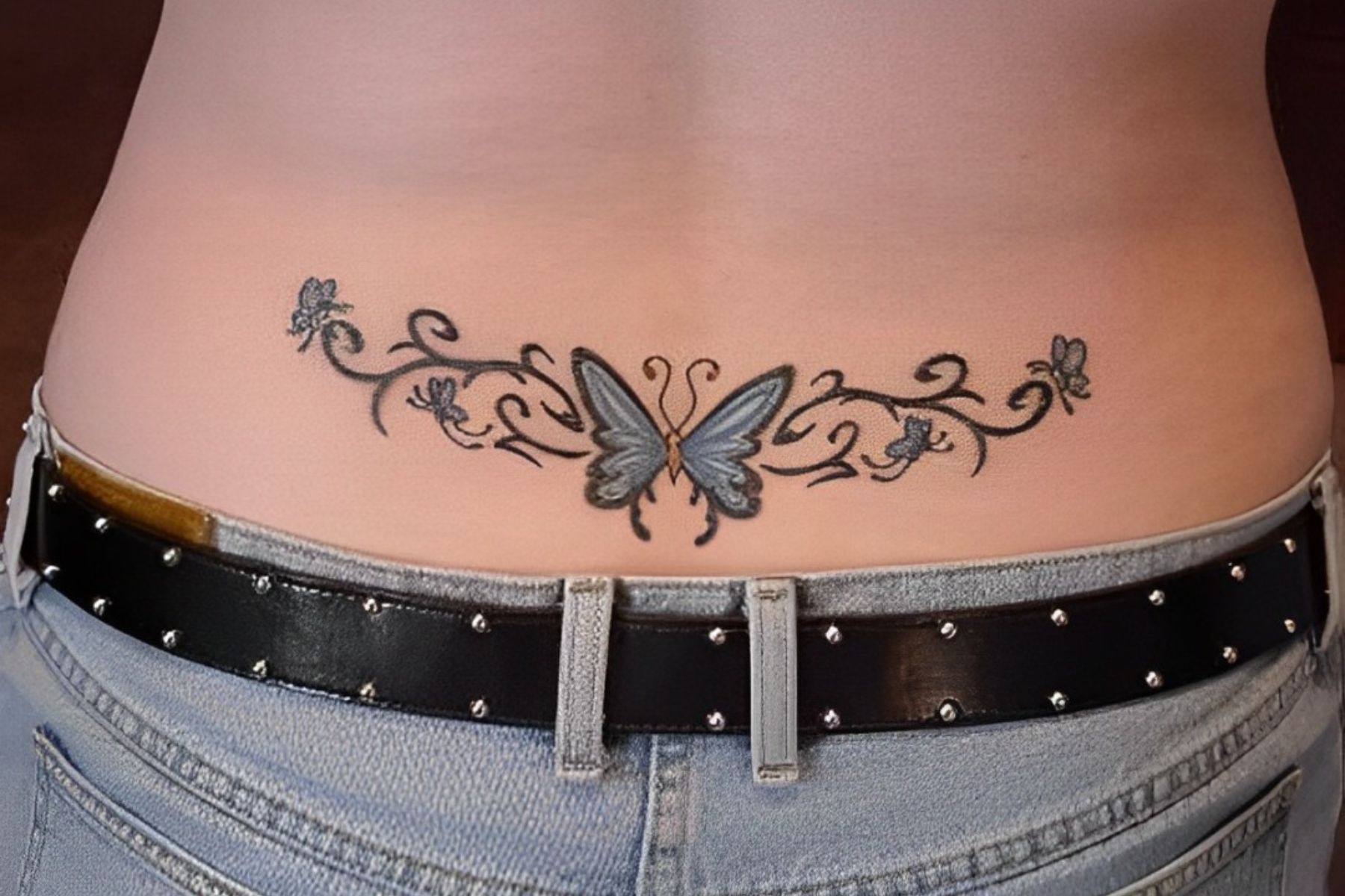 A man has a butterfly tattoo on his lower back