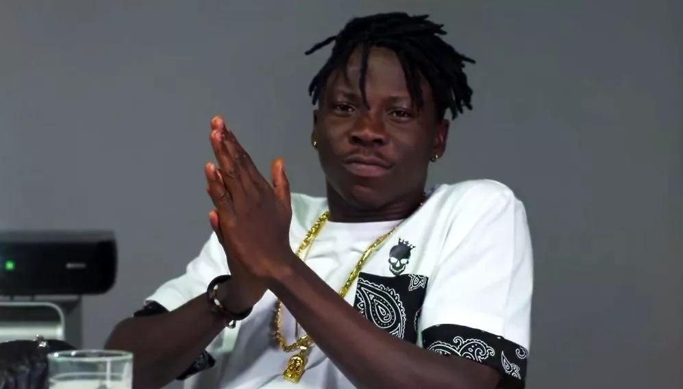 Stonebwoy rubs his palms together