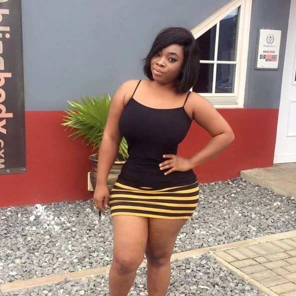 Moesha Boduong wearing a black blouse and a stripped skirt