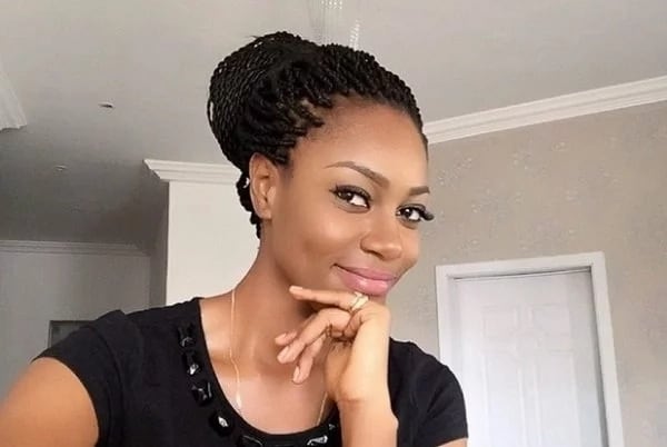 Yvonne Nelson in a black dress, resting her chin on her hand
