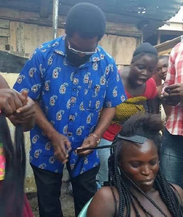 Alfred Okoe Vanderpuije plaits woman's hair