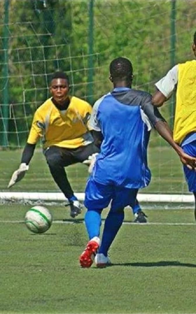 A goalkeeper about to catch a ball