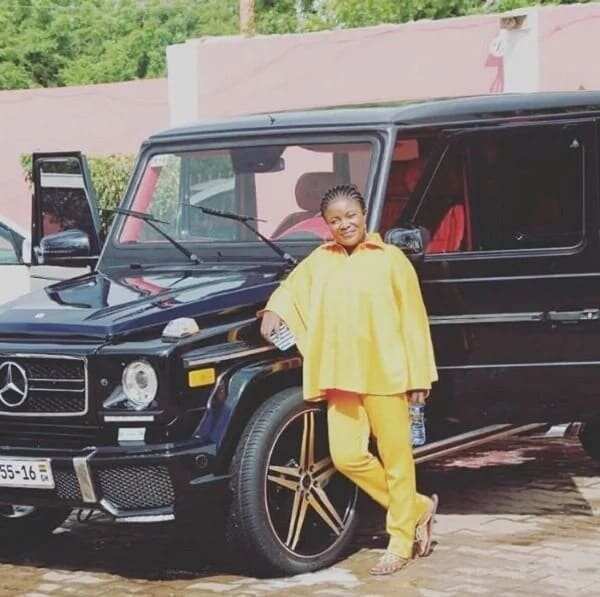 Ohemaa Mercy standing by one of her many cars
