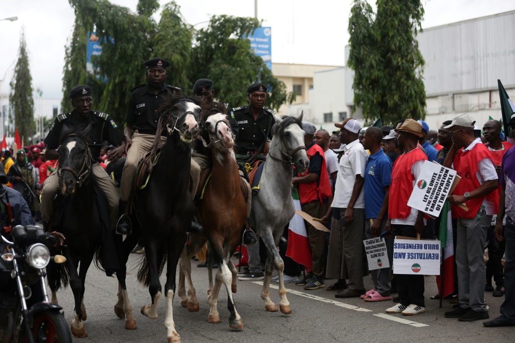 Mounted Nigerian police officers keep an eye on striking workers in Abuja